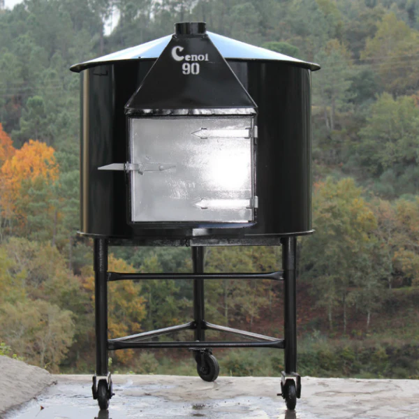 orno a lenha portátil, em barro cozido, com rodas e manivela para fácil transporte. Exterior em ferro polido com porta reforçada e interior em argila para conservação do calor. Ideal para cozinhar ao ar livre, certificação CE incluída. Disponível em vários tamanhos.