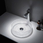 Lavatório de pousar redondo Mumbai em vidro transparente com acabamento mate, instalado sobre tampo